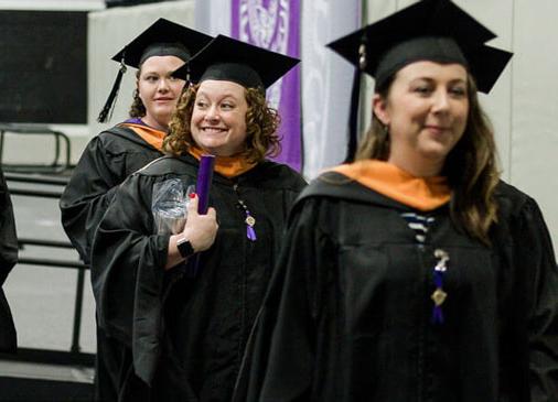nursing graduates smile as they leave commencement stage